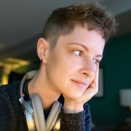 headshot of Katie with her hand on her face, looking away from the camera